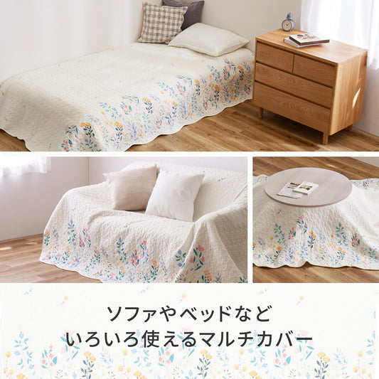アイボリーの優しい色合いにカラフルな花柄がプリントされたキルトのマルチカバー